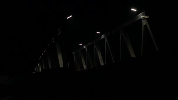 Oude ijzeren brug met autoverkeer op avond. koplampen licht van passerende auto's. 4k — Stockvideo
