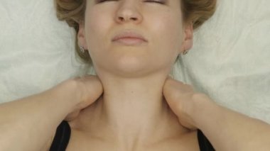 yatakta yatan boyun masajı. sarışın kadın evde kendi kendine masaj, Anti-aging yüz masaj yapıyor