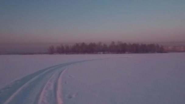 Πετώντας πάνω από το χιόνι πεδίο ηλιοβασίλεμα — Αρχείο Βίντεο