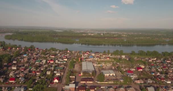 Avanzando lentamente hacia adelante aérea estableciendo tiro de la pequeña ciudad con pequeño barco en un río. 4K — Vídeos de Stock