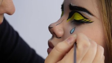 Komik karikatür makyaj. komik pop sanat makyaj yaparken profesyonel makyaj sanatçısı