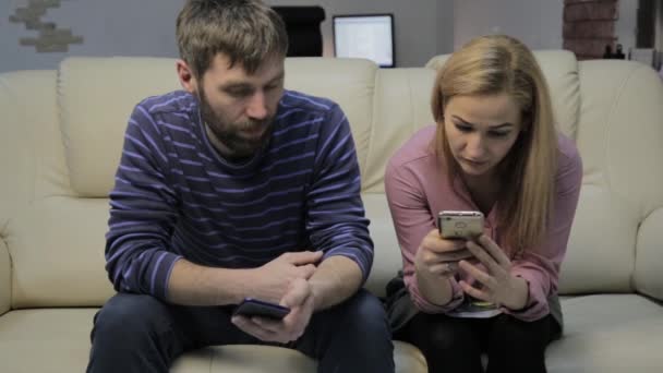 Esposa y marido se comunican mientras miran los teléfonos inteligentes. concepto de vida familiar — Vídeos de Stock
