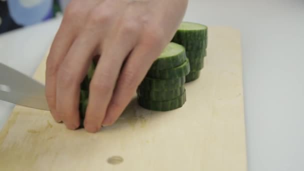 Affettare il cetriolo per la lattuga. Taglio verdure su tavola da cucina in legno . — Video Stock