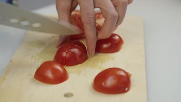 Mujeres con cuchillo de cocina diapositiva cortar tomate fresco en tabla de cortar de madera. Cortar tomate para lechuga o pizza — Vídeos de Stock