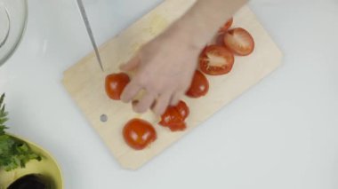 mutfak bıçak slayt kullanarak kadınlar ahşap kesme tahtası üzerinde taze domates kes. Domates marul veya pizza dilimleme. Üstten görünüm 4k