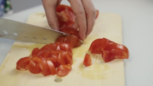 妇女使用菜刀滑动切割新鲜的西红柿在木制切菜板上。生菜或比萨饼用番茄切片 — 图库视频影像