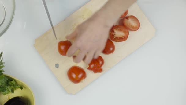 Mujeres con cuchillo de cocina diapositiva cortar tomate fresco en tabla de cortar de madera. Cortar tomate para lechuga o pizza. Vista superior 4K — Vídeos de Stock