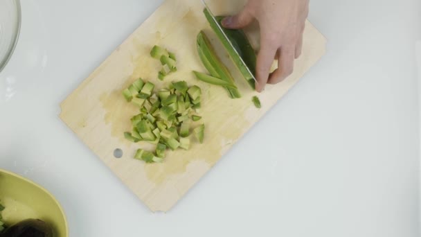Snij een avocado in stukjes. Snijden van vruchten voor sla. Bovenaanzicht 4k — Stockvideo