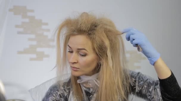 Szőke nő festékek magát a haját. Színezés a hajad otthon. — Stock videók
