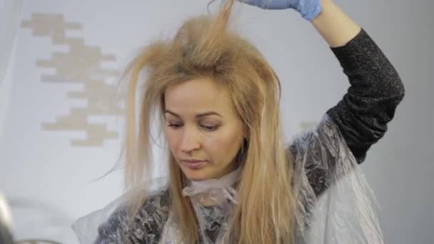 Femme blonde se teint les cheveux elle-même. Coloriage des cheveux à la maison . — Video