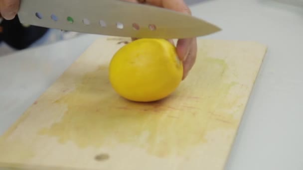 Mujer cortando un limón en la tabla de cortar — Vídeos de Stock