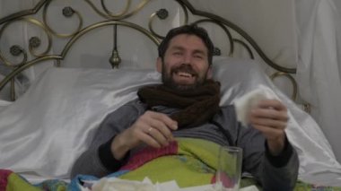 Üzgün hasta adam boynuna sıcak bir eşarp ile kadın hapları ve bir termometre getiriyor. ağır çekim