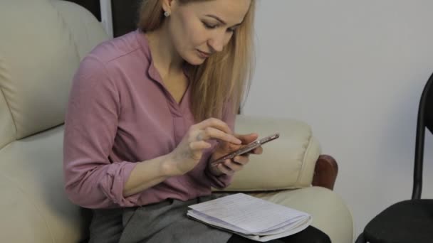 Blond elev läser hennes anteckningar, förbereder att ta prov på en soffa hemma — Stockvideo