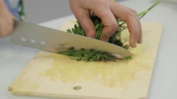 Giovane donna preparare e tagliare vegetazione lussureggiante per vegan — Video Stock