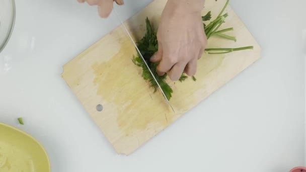 Giovane donna preparare e tagliare vegetazione lussureggiante per vegan — Video Stock
