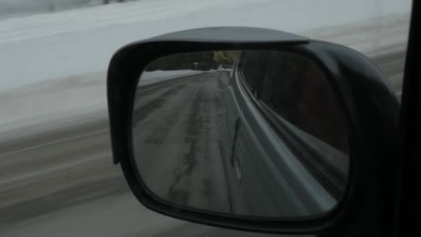 Reflet paysage montagneux dans le rétroviseur latéral de la voiture. saison hivernale. au ralenti — Video