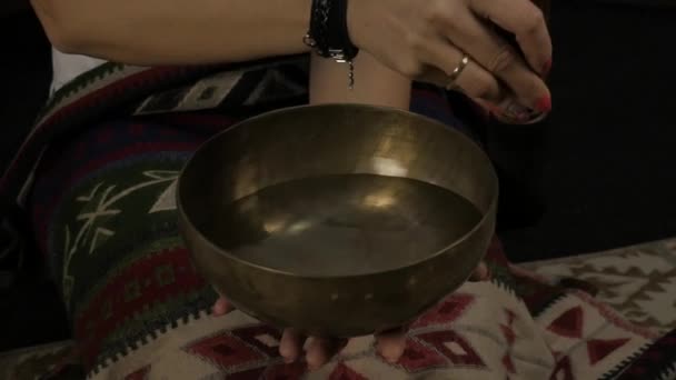 Женщина, оперирующая с тибетскими чашами. Инструктор йоги проводит медитацию. замедленное движение — стоковое видео