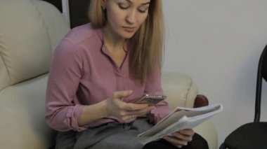 sarışın öğrenci notlarını okur, evde kanepede sınava hazırlar