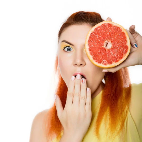 Mujer pelirroja joven con pomelo en sus manos retrato de estudio sobre un fondo blanco. concepto de alimentación saludable —  Fotos de Stock