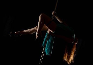 Gece kulübü çok güzel seksi dansçı. karanlık bir arka plan üzerinde bir yarık ile uzun turkuaz giysili bir kadına. metniniz için boş alan