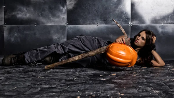 Çelik arka plan, kazma ve turuncu kask bir katta oturan güzel yorgun seksi madenci işçi yakındaki yatıyor — Stok fotoğraf