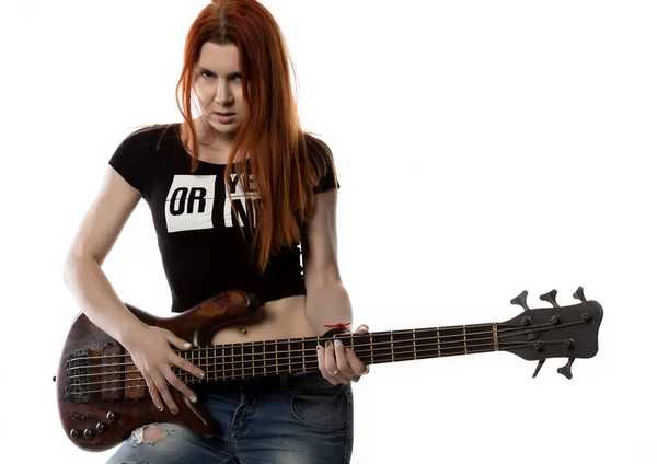 Rödhårig kvinna med gitarr på en vit bakgrund. Rock-flicka som leker på en gitarr. ledigt utrymme för text — Stockfoto