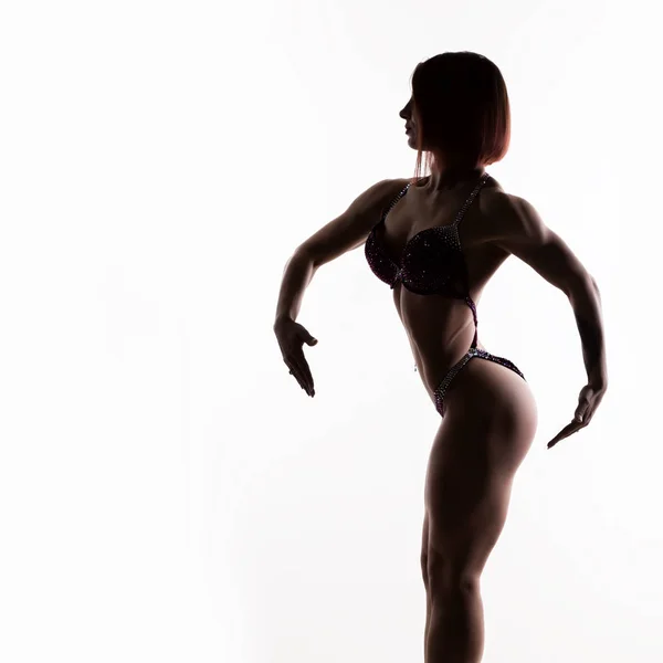 Hermosa mujer fitness, silueta de chica muscular posa sobre fondo blanco. culturismo femenino. espacio libre para su texto — Foto de Stock