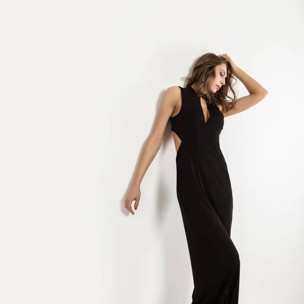 Hermosa mujer elegante posando en vestido largo negro sobre un fondo blanco. espacio libre para su texto —  Fotos de Stock
