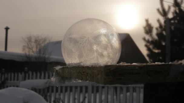 Frosty zeepbel. Bevroren sneeuw Globe. Sneeuwvlok ijs patronen frosted op bal van zeep. Winter zonsondergang achtergrond — Stockvideo