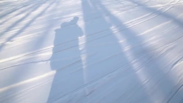 La sombra de los esquiadores sobre la nieve. T-bar telesilla tirar de los esquiadores a la cima de la pista — Vídeos de Stock