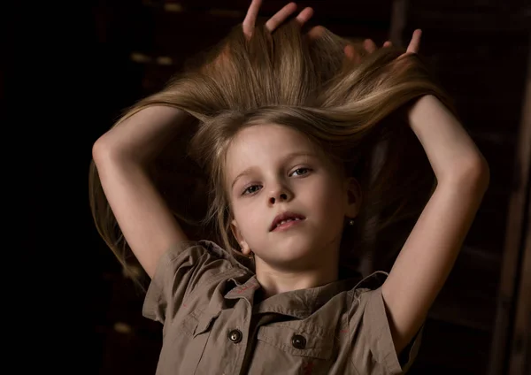 Vacker härlig liten blond tjej med olika känslor på en mörk bakgrund — Stockfoto