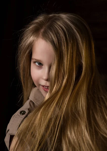 Όμορφο υπέροχο μικρό ξανθό κορίτσι με διαφορετικά συναισθήματα σε ένα σκοτεινό φόντο — Φωτογραφία Αρχείου