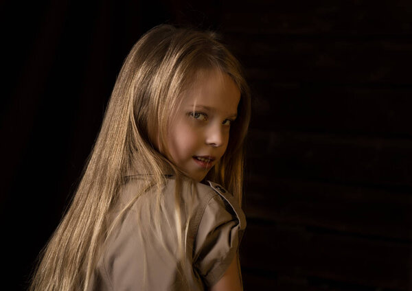 beautiful lovely little blonde girl with different emotions on a dark background