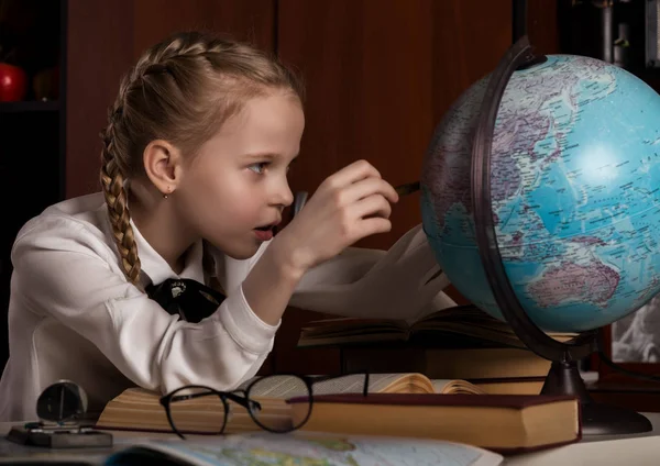 Colegiala haciendo la tarea, niña rubia estudiando en casa en la mesa. educación infantil —  Fotos de Stock