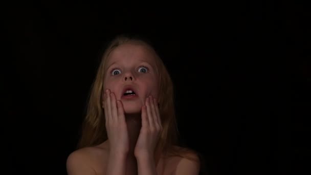 Young girl with live emotions under water drops. child screaming on a dark background. expression of different emotions. slow motion — Stockvideo