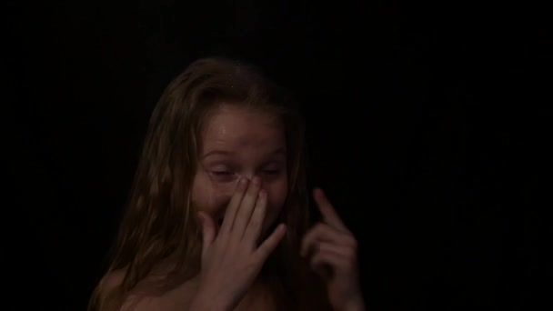 Young girl with live emotions under water drops. child screaming on a dark background. expression of different emotions. slow motion — Stockvideo