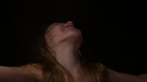 Девушка с живыми эмоциями под каплями воды. ребенок кричит на темном фоне. выражение различных эмоций. 4K — стоковое видео