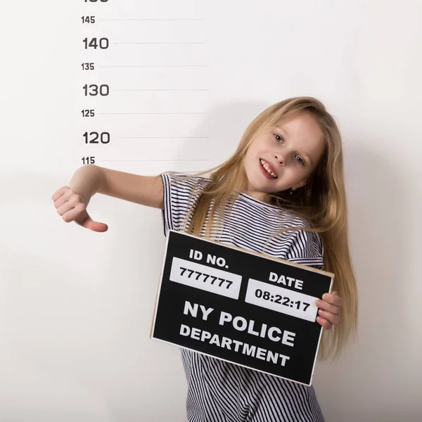 Junge schöne blonde Kind mit einem Schild, kriminelle Tasse Schüsse. schwierige Kinder, soziale Spannungen — Stockfoto