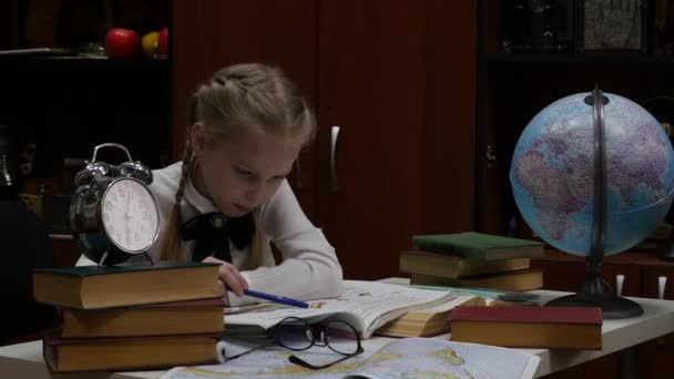 Uczennica robi pracę domową, trochę blond dziewczyna studing w domu przy stole. edukacji dziecięcej. 4K — Wideo stockowe