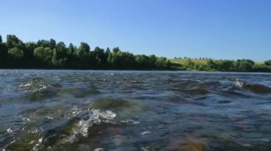 geniş sığ nehirhızlı akış, su ile alt kısmında bir taş görünümü. su üzerinde güneş parlama