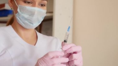 Kadın doktor, hastanedeki hemşire şırıngayı sıvı ilaçla gösteriyor. Sağlık ve tıbbi kavram. yavaş çekim