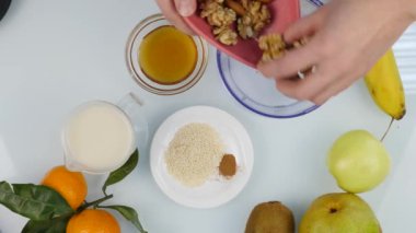 Üstten görünüm ahşap tahta üzerinde büyük bıçak ile kesme kuru kayısı eller. 4k