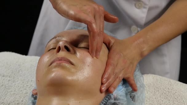 Massage du visage en plastique dans le salon de spa. femme bénéficie des services d'un massothérapeute professionnel. au ralenti — Video