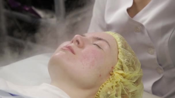 Доктор очищає жіночу шкіру парою. молода жінка з проблемною шкірою у косметолога. концепція косметології — стокове відео