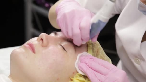 Mujer joven con problemas de piel, limpieza mecánica profunda de la cara. esteticista limpia la piel de las mujeres con equipo cosmético — Vídeos de Stock