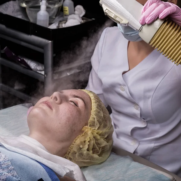 Doktor bir buhar ile kadın cilt temizler. güzellik te sorunlu genç kadın. Kozmetoloji kavramı