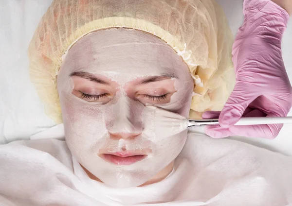 Kosmetolog stosowania maski twarzy do skóry problem. Młoda kobieta z procedurami oczyszczania skóry — Zdjęcie stockowe