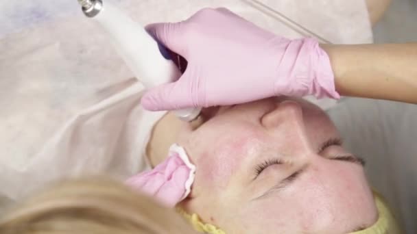 Mulher jovem com a pele de problema, limpeza de cara profunda mecânica. esteticista limpa a pele das mulheres com equipamentos cosméticos — Vídeo de Stock