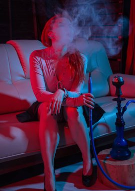 Seksi kızıl saçlı kadın kırmızı mavi tonları elektronik nargile vaping