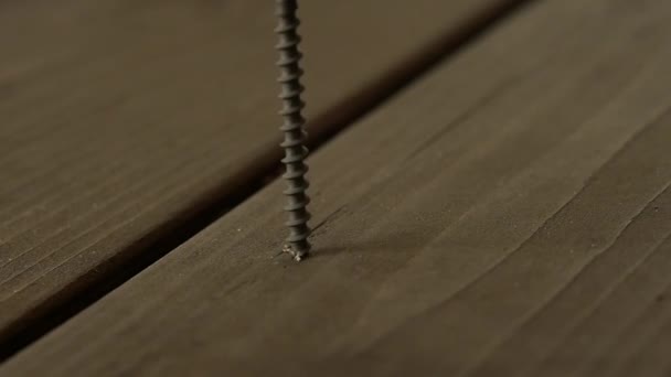 Carpenter fixes the wooden floor with screws with a screwdriver. slow motion — Stock Video